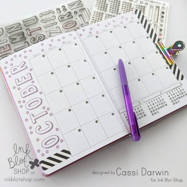 Open planner with October page and decorative elements on a white surface