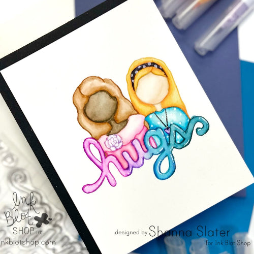 Colorful illustration of friends with 'hugs' bubble text on a white card, designed by Shanna Slater for Ink Blot Shop.