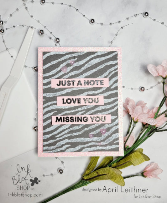 Card with text 'Just a Note, Love You, Missing You' on a zebra print background, featuring products from Ink Blot Shop